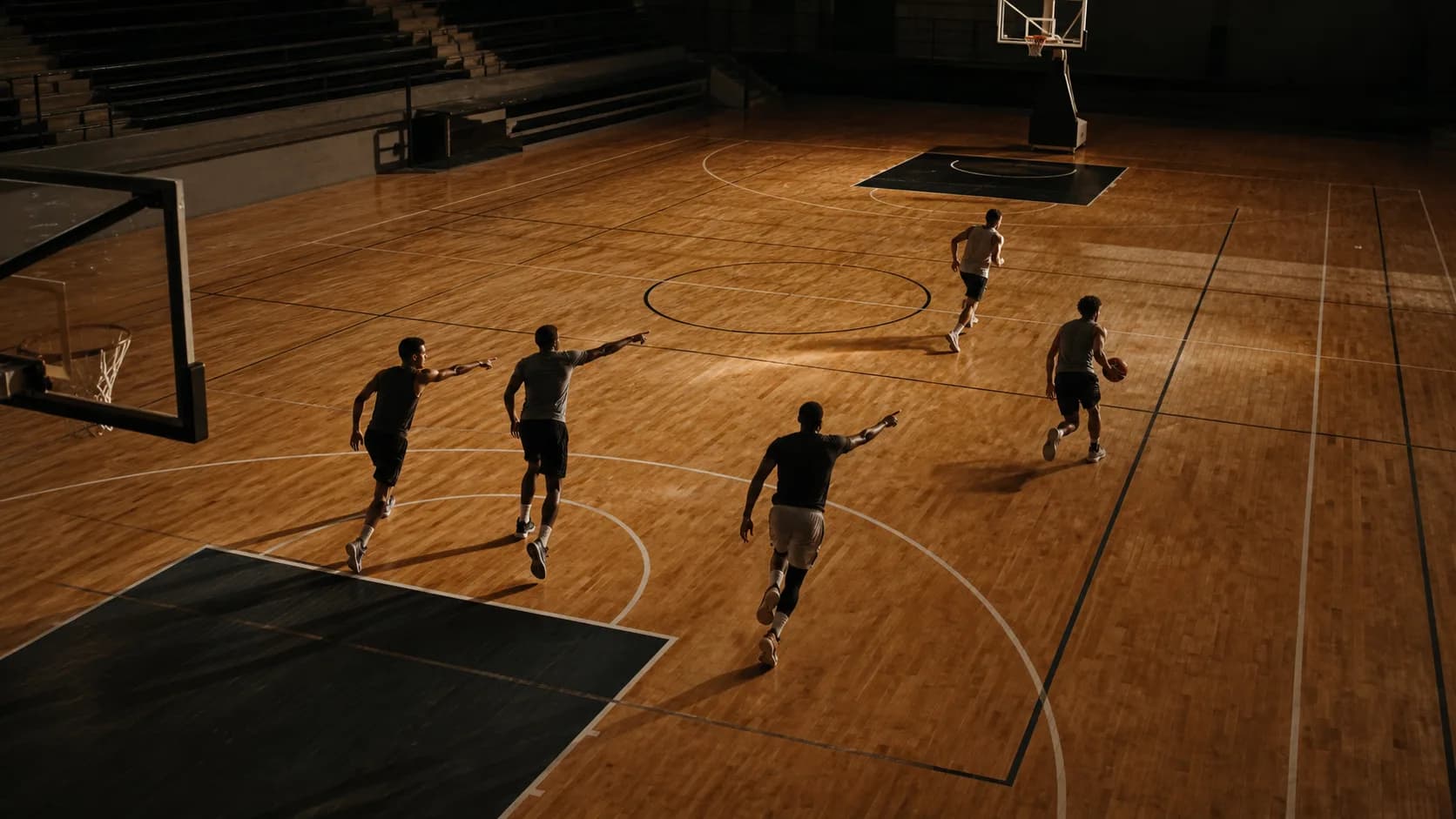 Three defenders sprinting back and pointing out assignments in transition